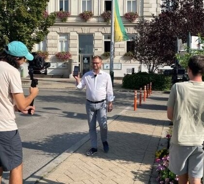 Am Bild zu sehen der Mistelbacher Bürgermeister Stubenvoll mit 2 Filmleuten beim Videodreh am Stadtplatz Mistelbach für Bewerbung der Cities App