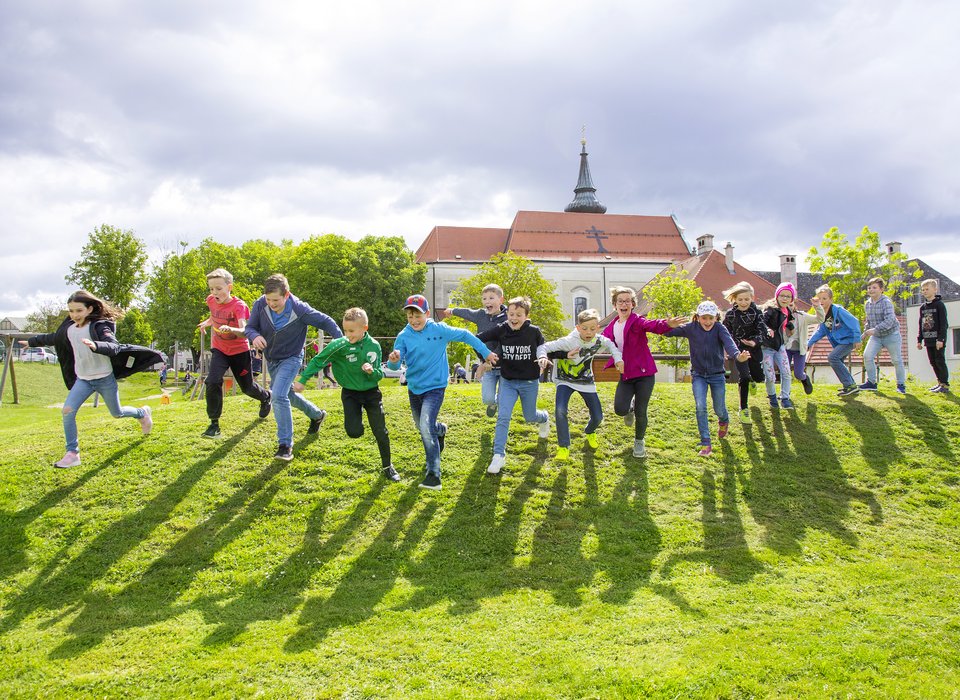 Viele Kinder laufen nebeneinander einen Hügel hinunter