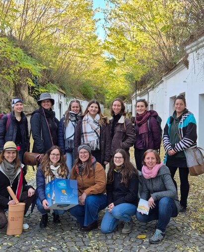 Gruppenfoto in Kellergasse Radyweg bei der Kellergassenführung Die teilnehmenden Studierenden der HAUP gemeinsam mit Christine Filipp (Geschäftsführerin LEADER Region Weinviertel Ost), Elisabeth Hainfellner (Vizerektorin der HAUP), Caroline Fribert (Projektmitarbeiterin LEADER Region Weinviertel Ost) und Marlene Nagl (Projektmitarbeiterin Region Marchfeld) in der Kellergasse Radyweg bei der Kellergassenführung
