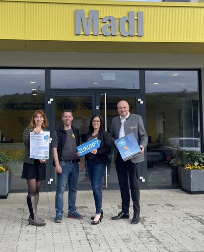 Pressefoto vier Menschen vor dem Geschäft Madl