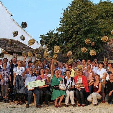 Große Gruppe werfen viele Weinviertelhüte in die Höhe