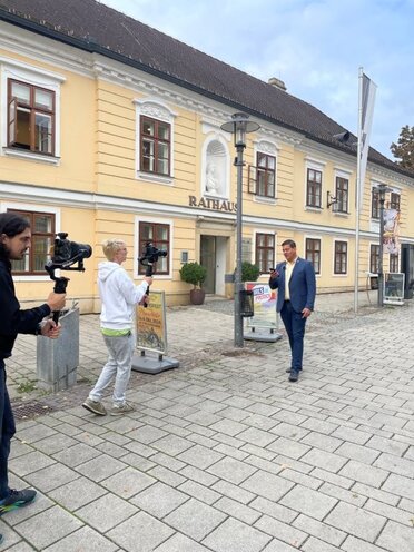 Filmaufnahmen auf Hauptplatz in Wolkersdorf. Im Vordergrund ist das Filmteam zu sehen, im Hintergrund der Bürgermeister.