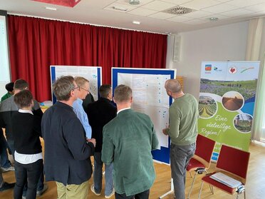 Vor einer Flipchart diksutieren 7 Personen zum Thema Leerstand im Rahmen eines Workshops.