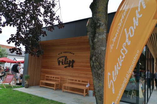 Foto von der Sommergenusstour vor dem Obstbau Filipp mit der Sommer Genusstour Fahne
