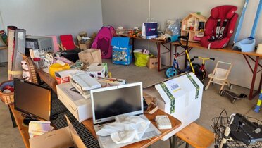 Beispielbild Kreislaufwirtschaft Hochleithen, C: Christine Filipp Gebrauchte Elektrogeräte, Spielsachen, Kinderfahrzeuge, Möbel und Haushaltsgegenstände sind zur Weitergabe in Hochleithen auf Tischen und Regalen aufgestellt.