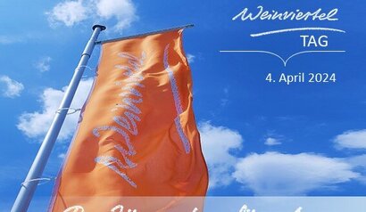 Zu sehen ist der Himmel mit Wolken und einer orangenen Weinviertel-Fahne. Darauf steht der Text SAVE THE DATE Weinviertel Tag 4.4.2024 und Die Jüngsten für das Weinviertel begeistern