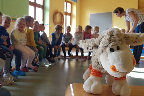 Foto von dem Kuscheltier Schaf Lotte, bei einem Besuch in einer Volksschule