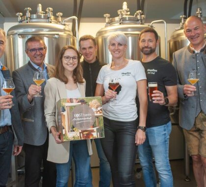 Das Organisationsteam der Sommer Genusstour im Weinviertel beim Betrieb Hopfius. Im Hintergrund sind Bierkessel zu sehen.