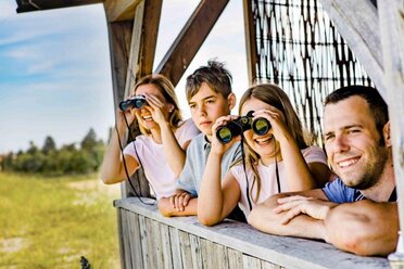 Kinder auf einer Aussichtplattform die in die Natur schauen.