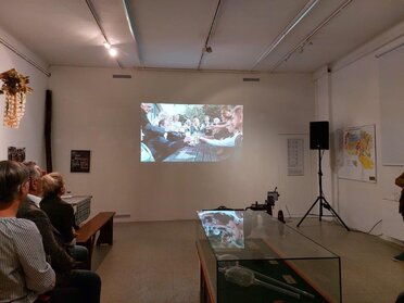 Im Rahmen der Eröffnung der Ausstellung "325 Jahre Hauerzunft Mistelbach" wurde auch ein Film über die Hauerzunft präsentiert, am Bild ist eine weiße Wand auf der der Film abgespielt wird, zu sehen.