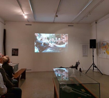 Im Rahmen der Eröffnung der Ausstellung "325 Jahre Hauerzunft Mistelbach" wurde auch ein Film über die Hauerzunft präsentiert, am Bild ist eine weiße Wand auf der der Film abgespielt wird, zu sehen.