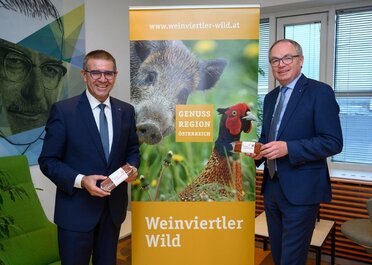 Präsentation neuen Wurst "Wilde Dreikantige" mit LHStv Pernkopf und LAbg Schulz vor einem Roll up der Genuss Region Weinviertler Wild