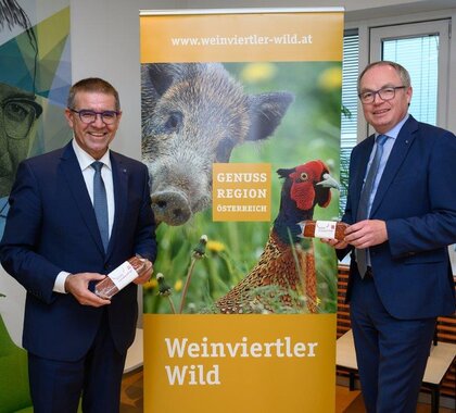 Präsentation neuen Wurst "Wilde Dreikantige" mit LHStv Pernkopf und LAbg Schulz vor einem Roll up der Genuss Region Weinviertler Wild