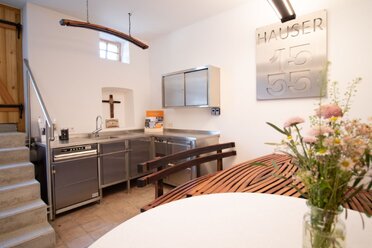 Im inneren des Presshauses befindet sich gegenüber des Eingangs ein Sitzplatz sowie an der Wand ein Küchenverbau aus Aluminium.