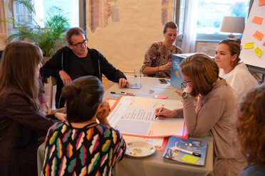 Vier Menschen sitzen an einem Tisch.Besprechen